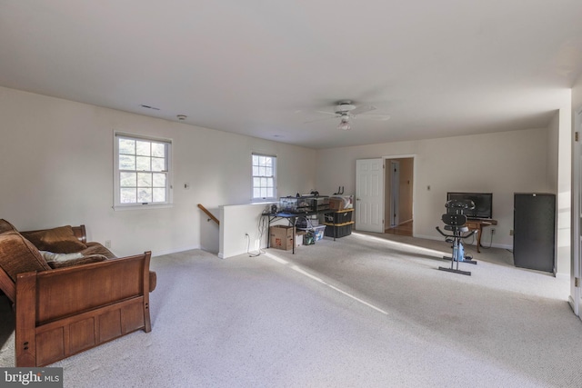 interior space featuring baseboards, ceiling fan, carpet floors, and an upstairs landing