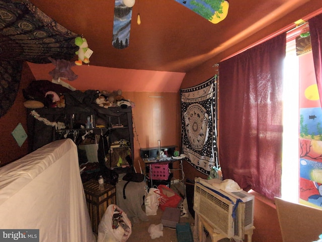 interior space with carpet floors, lofted ceiling, and an AC wall unit