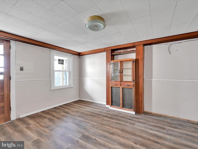 unfurnished living room featuring plenty of natural light, baseboards, and wood finished floors