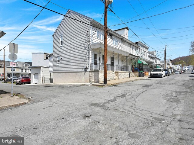 view of property exterior featuring a residential view and covered porch