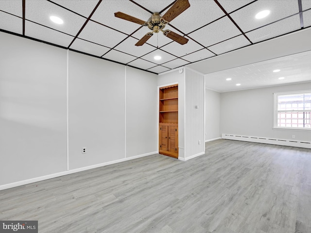 basement with a baseboard radiator, wood finished floors, a ceiling fan, and recessed lighting