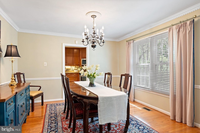 7185 Rivers Edge Rd, Columbia, MD 21044 - dining area featuring crown molding, light wood finished floors, baseboards, and an inviting chandelier