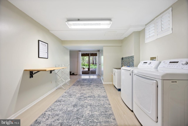 7185 Rivers Edge Rd, Columbia, MD 21044 - laundry area with cabinet space, washing machine and dryer, baseboards, and light wood-type flooring