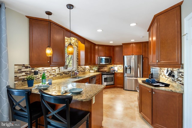 7185 Rivers Edge Rd, Columbia, MD 21044 - kitchen featuring stainless steel appliances, a sink, light stone countertops, a peninsula, and hanging light fixtures