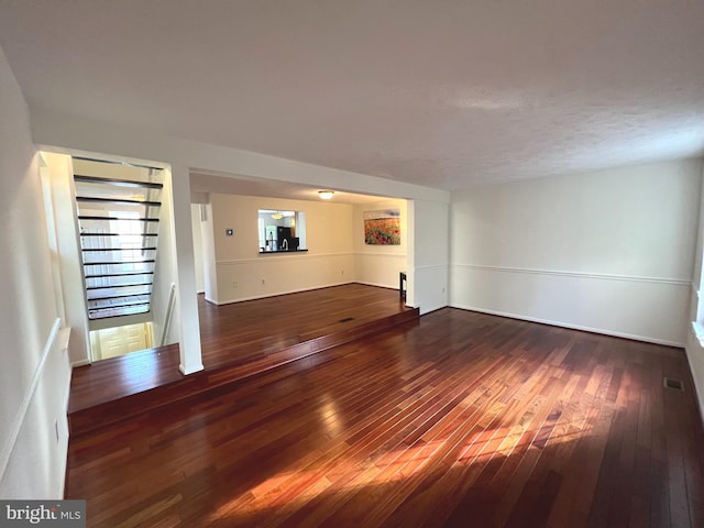 unfurnished living room featuring hardwood / wood-style floors and visible vents