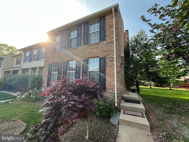 view of front of house with brick siding and a front lawn