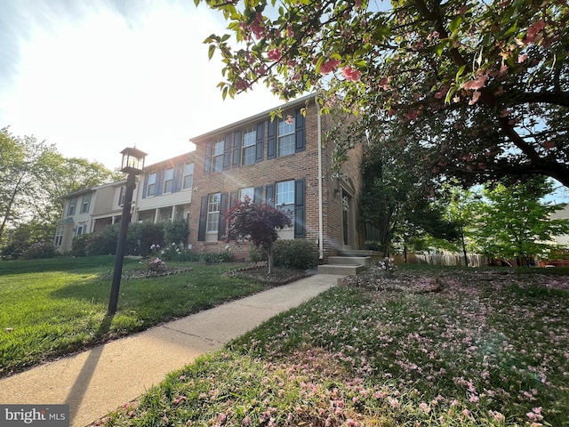 view of front of house with a front lawn and brick siding