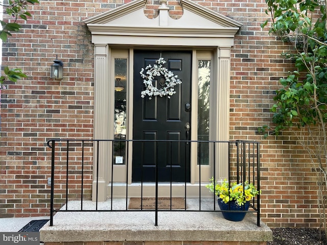 view of exterior entry with brick siding