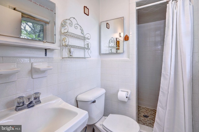 full bathroom with tile walls, toilet, a sink, and a tile shower