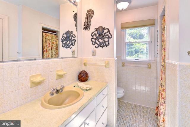 full bath with tile walls, tile patterned floors, a wainscoted wall, and toilet