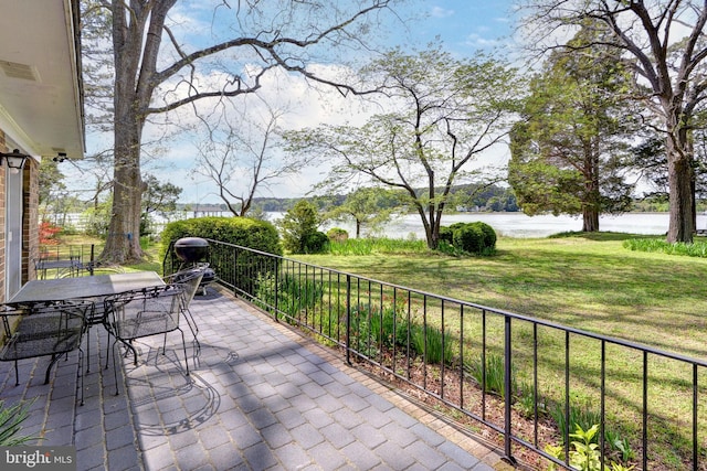view of patio with a water view and outdoor dining space