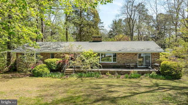 view of front of house featuring a front lawn, brick siding, and a deck
