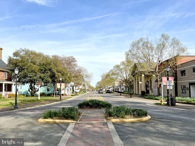 view of road featuring curbs, street lighting, and sidewalks