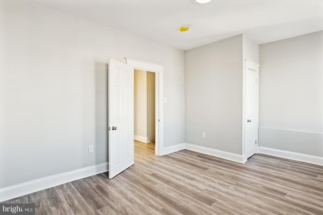 empty room with light wood-type flooring and baseboards