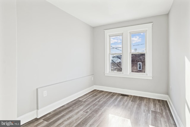 empty room with wood finished floors and baseboards