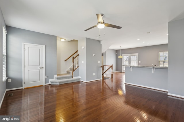 unfurnished living room with ceiling fan, hardwood / wood-style flooring, recessed lighting, and baseboards