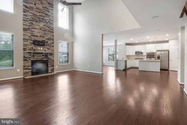 15916 Aerial View Rd, Woodbridge, VA 22193 - unfurnished living room with dark wood-style floors, plenty of natural light, a towering ceiling, baseboards, and recessed lighting