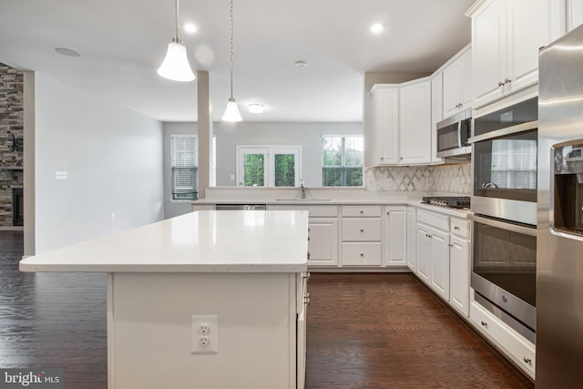15916 Aerial View Rd, Woodbridge, VA 22193 - kitchen with stainless steel appliances, a sink, dark wood finished floors, a kitchen island, and decorative backsplash