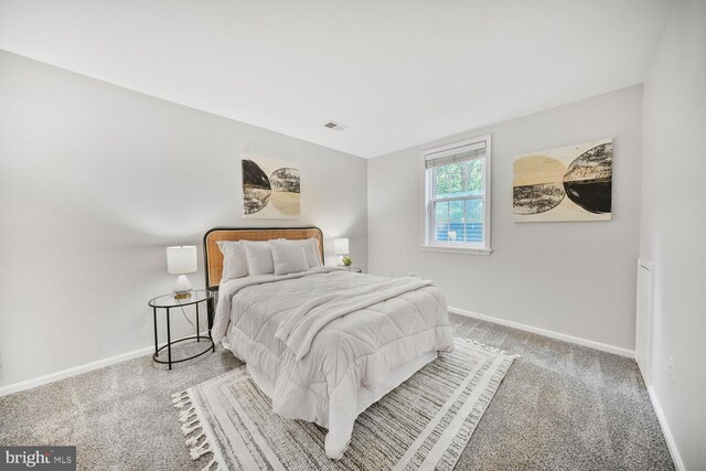bedroom with baseboards, visible vents, and carpet