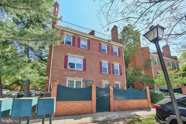 view of building exterior with fence private yard and central AC