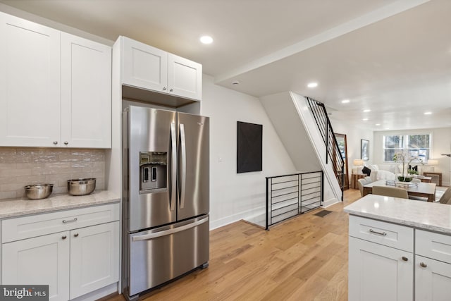kitchen with backsplash, stainless steel refrigerator with ice dispenser, light wood finished floors, and recessed lighting