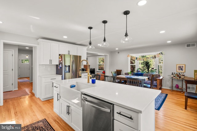 kitchen featuring recessed lighting, stainless steel appliances, light countertops, visible vents, and a sink