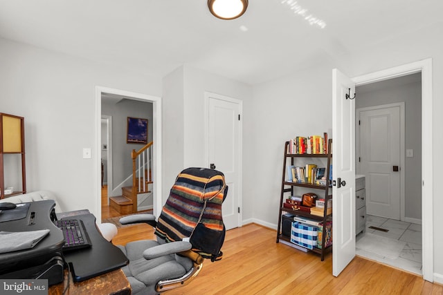 office area featuring baseboards and light wood-style flooring