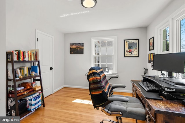 office space featuring light wood-type flooring and baseboards
