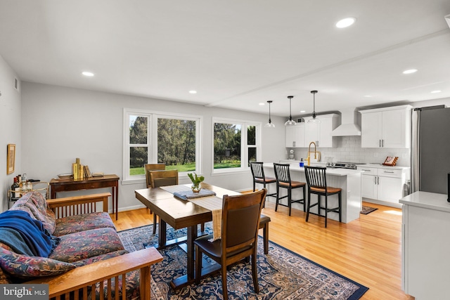 dining space with recessed lighting and light wood-style flooring