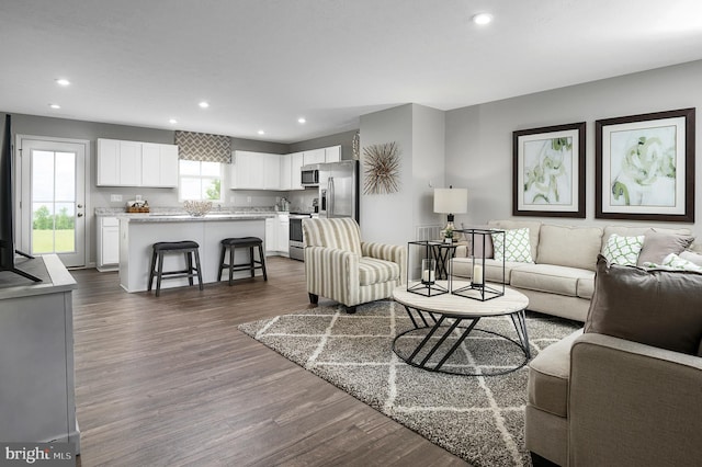 living area with recessed lighting and dark wood-style flooring