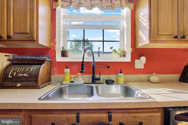 kitchen with brown cabinets, a sink, and plenty of natural light