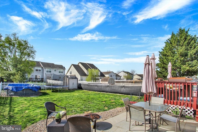 view of patio / terrace with a residential view, an outbuilding, a shed, and a fenced backyard