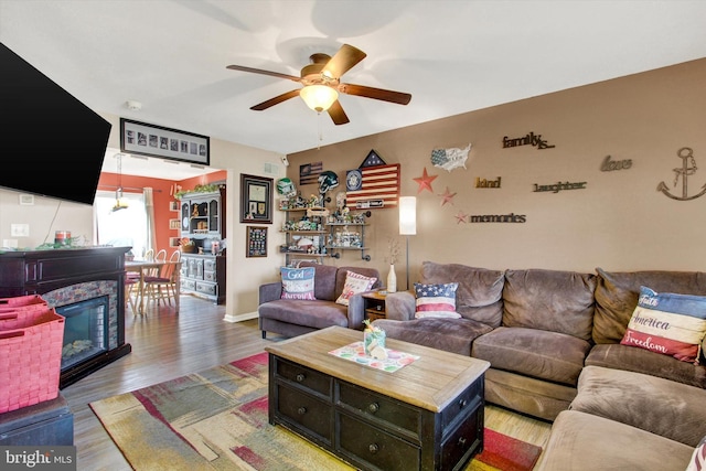 living room with a ceiling fan and wood finished floors