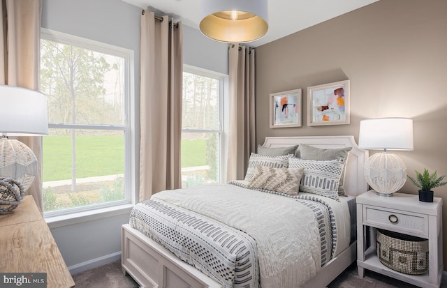 bedroom featuring dark colored carpet and baseboards