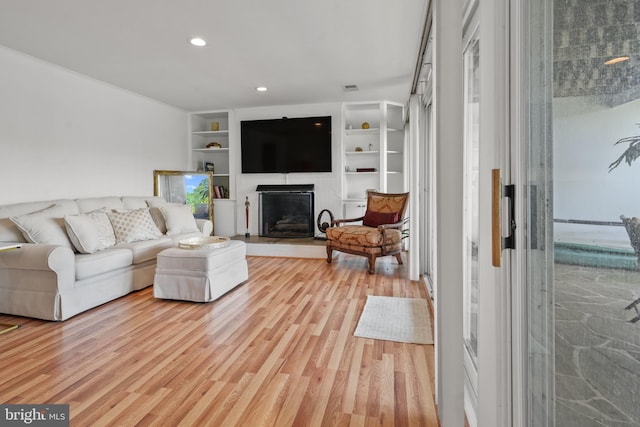 10323 Wilde Lake Ter, Columbia, MD 21044 - living area with a fireplace with raised hearth, light wood-style flooring, recessed lighting, and built in shelves