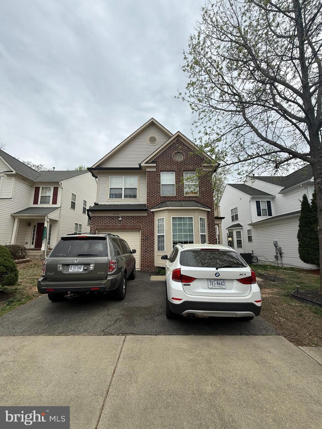 16558 Reservoir Loop, Dumfries, VA 22026 - view of front facade with an attached garage, driveway, and brick siding