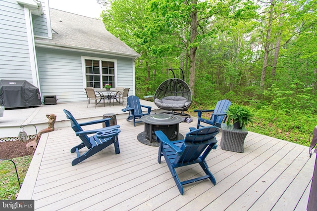 deck featuring outdoor dining area, a fire pit, and grilling area