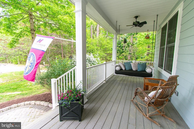 wooden terrace featuring a ceiling fan and a porch