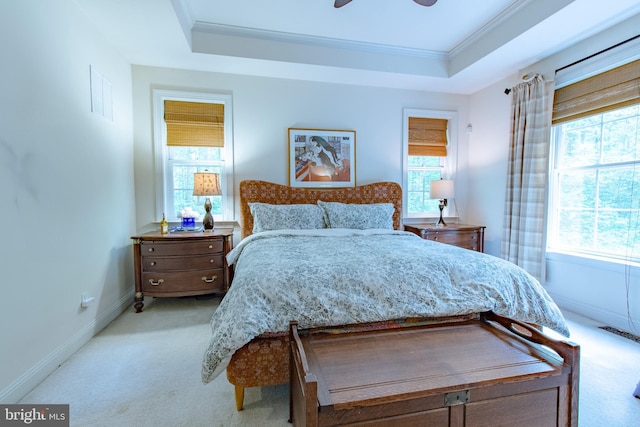 carpeted bedroom featuring crown molding, baseboards, a tray ceiling, and visible vents