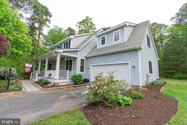 view of front of house featuring covered porch, central AC, driveway, and a shingled roof