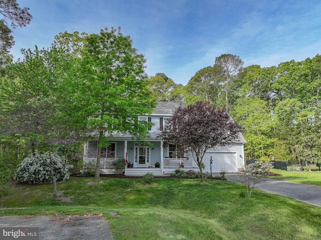 obstructed view of property with covered porch, driveway, and a front yard