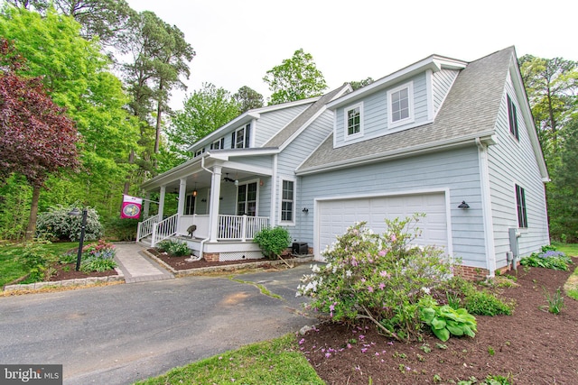 view of front of house featuring roof with shingles, a porch, and driveway
