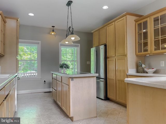 kitchen with freestanding refrigerator, a center island, light countertops, light brown cabinetry, and recessed lighting