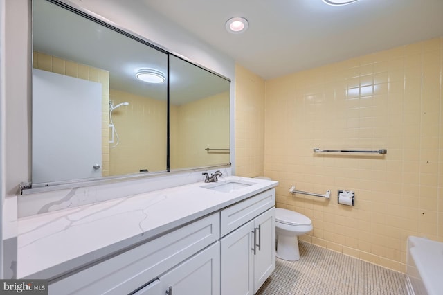 full bath featuring tile patterned floors, vanity, a bathtub, tile walls, and toilet