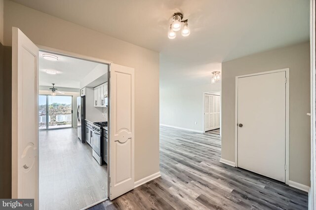 corridor featuring baseboards and wood finished floors