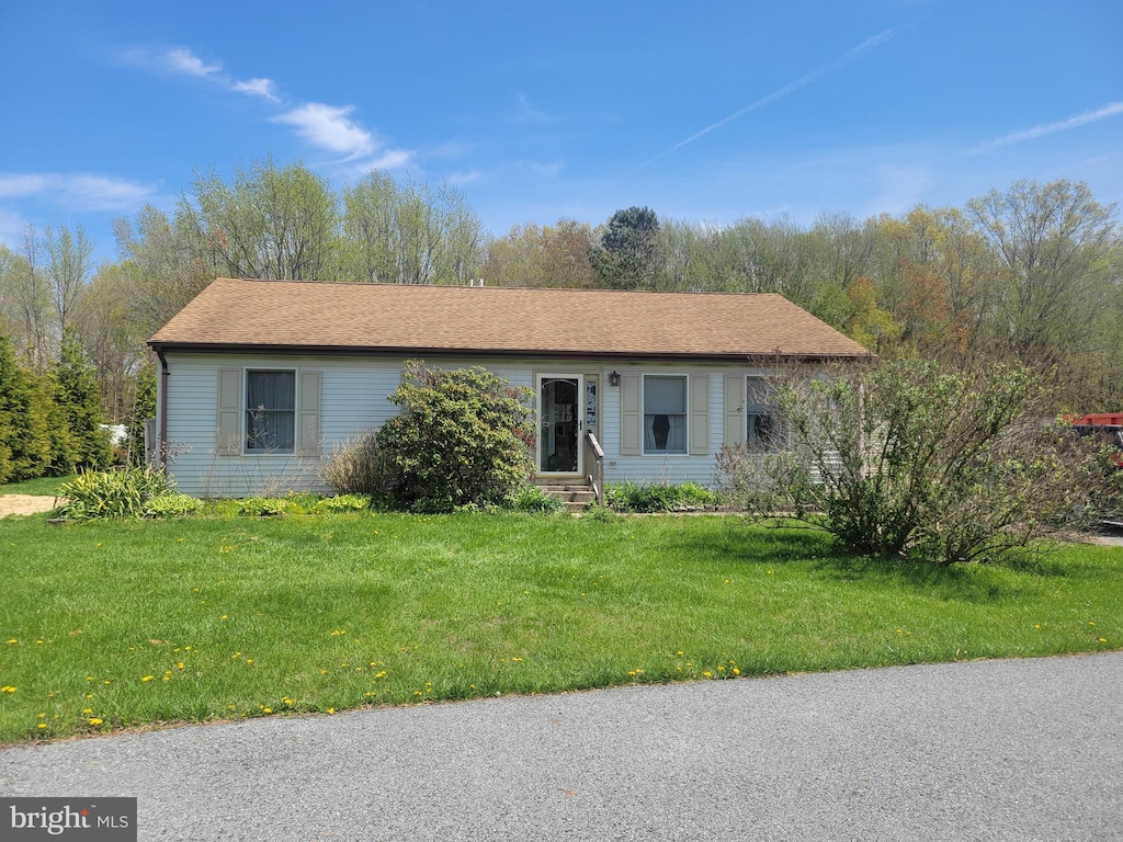 ranch-style home with entry steps and a front yard