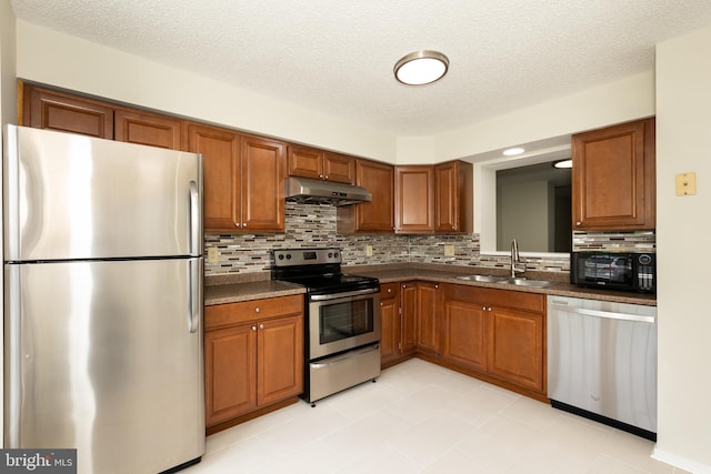 19320 Liberty Heights Ln, Germantown, MD 20874 - kitchen with stainless steel appliances, under cabinet range hood, dark countertops, backsplash, and brown cabinets