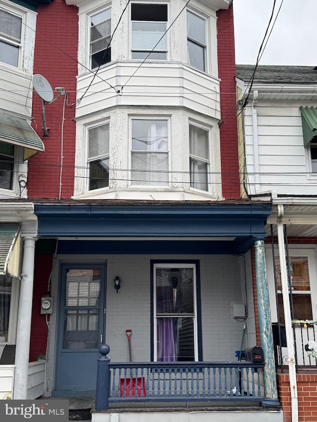 view of front of house with a porch and brick siding