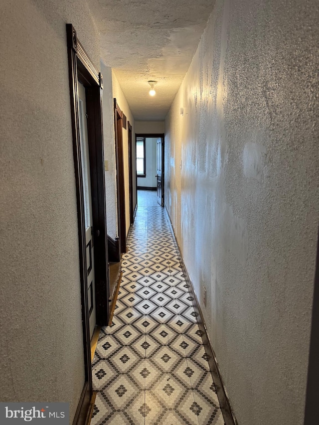 hall featuring a textured wall