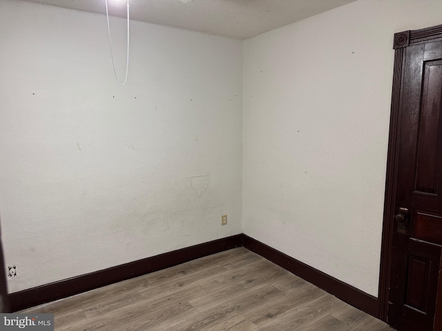 empty room with light wood-style flooring and baseboards